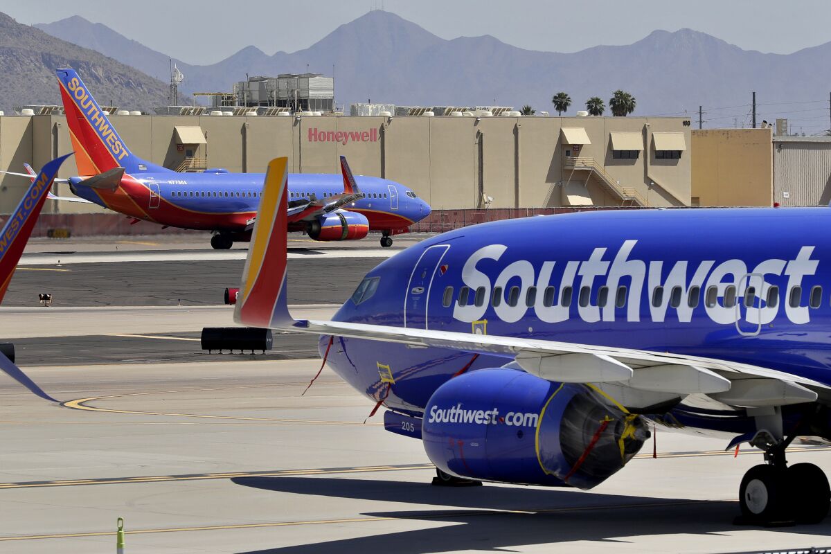 FILE - Southwest Airlines jets are stored at Sky Harbor International Airport in Phoenix, April 28, 2020. Southwest Airlines said Wednesday, Dec. 7, 2022, that it is bringing back dividends for shareholders, which it suspended when the pandemic devastated the airline business in early 2020. (AP Photo/Matt York, File)