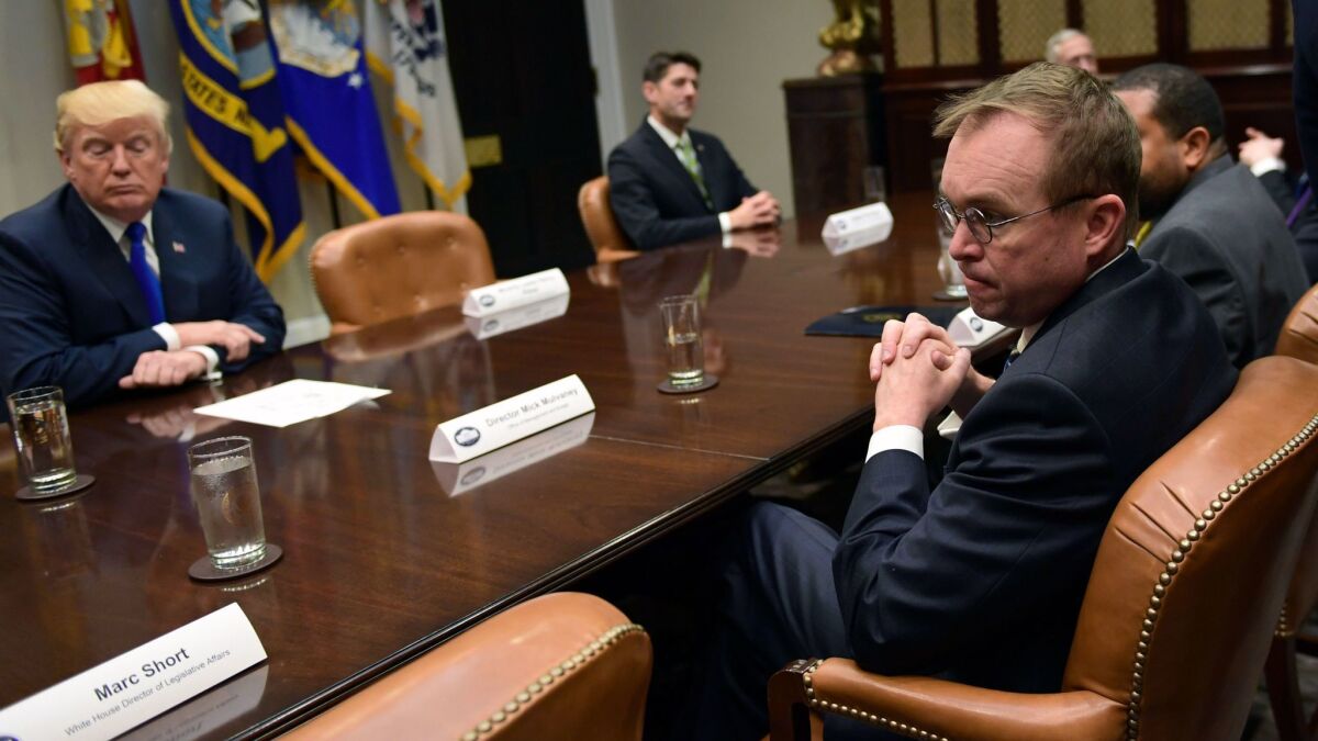 White House budget director Mick Mulvaney, right, attends a meeting with President Trump in Washington on Nov. 28.