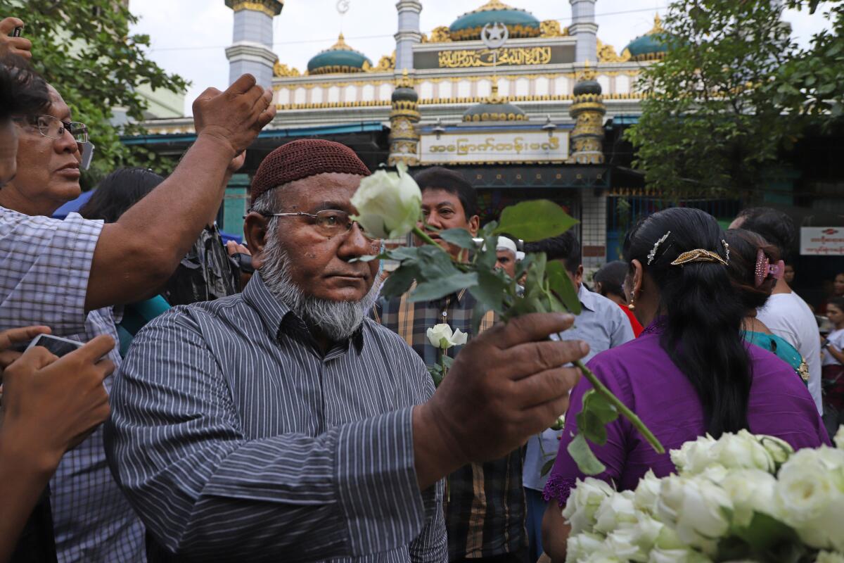 Muslims receive white roses from Buddhists at Joon Mosque in Mandalay on May 30, 2019, as part of a campaign promoting religious harmony.
