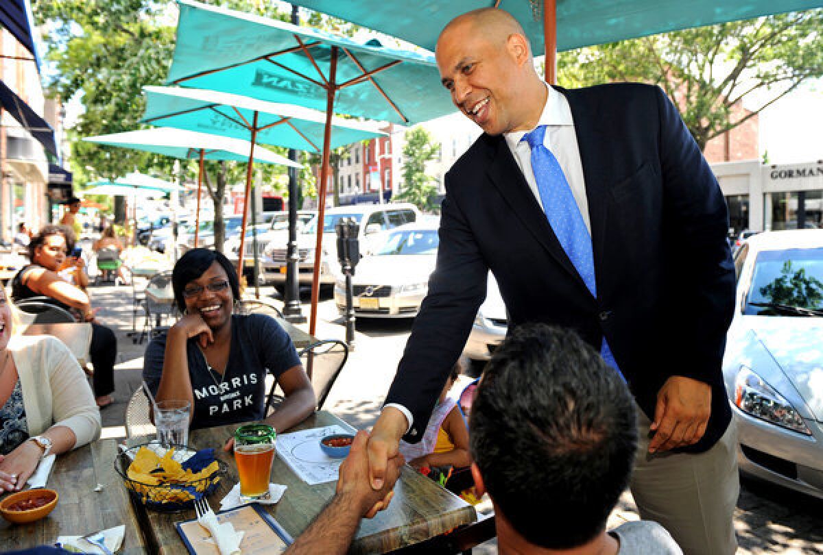 Newark Mayor Cory Booker greets diners in Englewood, N.J., while campaigning for the U.S. Senate seat held by the late Sen. Frank R. Lautenberg.
