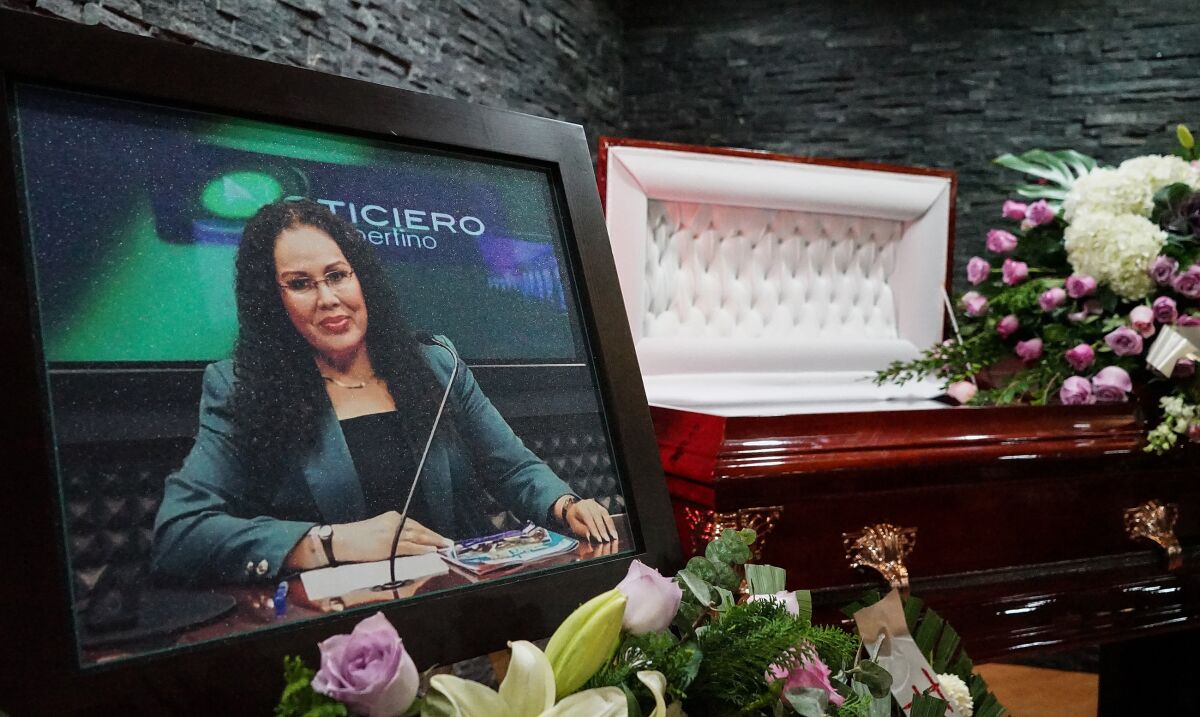 A photograph of journalist Lourdes Maldonado stands beside her coffin during her funeral