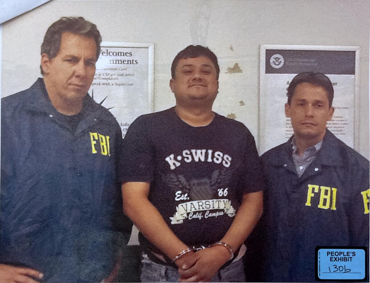 Jose Saenz, flanked by FBI agents.
