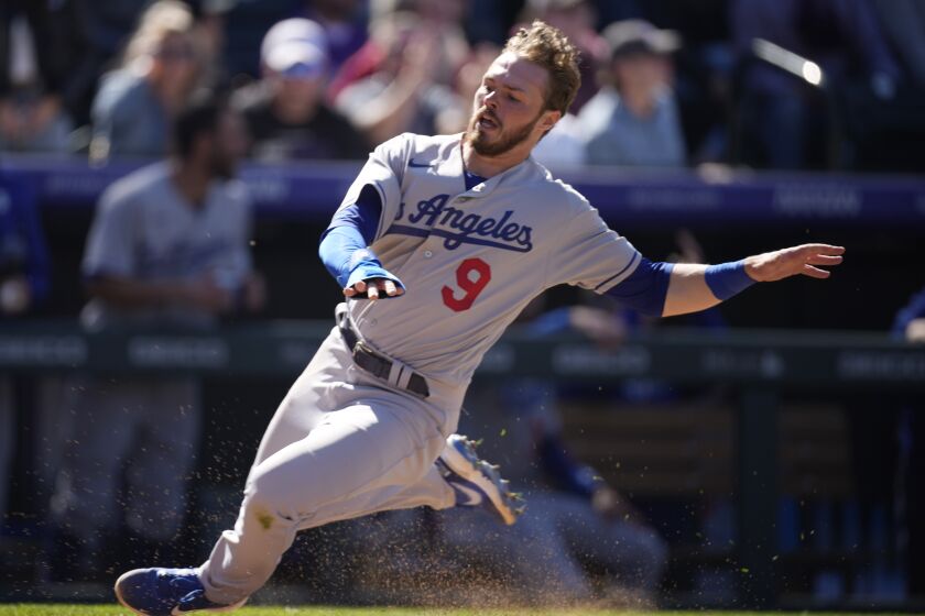 Los Angeles Dodgers' Gavin Lux slides safely into home plate to score on a double hit by Mookie Betts.