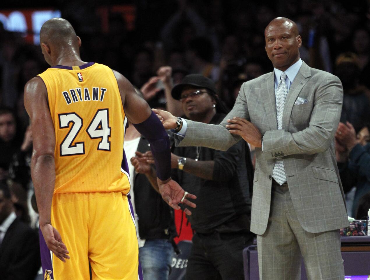 Lakers Coach Byron Scott high-fives forward Kobe Bryant after replacing him in the final moments of the game against the Spurs.