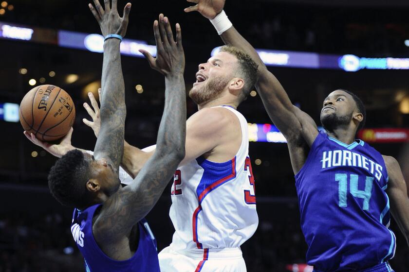 Clippers' Blake Griffin scores between Hornets' Marvin Williams, left, and Michael Kidd-Gilchrist at Staples Center on Tuesday. The NBA announced Wednesday that the two teams will travel to China for a two-game exhibition in October.