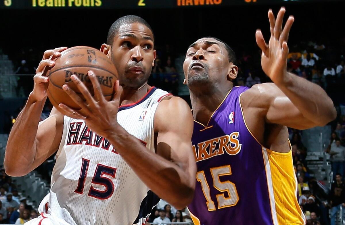 Metta World Peace, shown defending Atlanta's Al Horford, has kept his Twitter followers entertained, if not informed on his status with the Lakers.