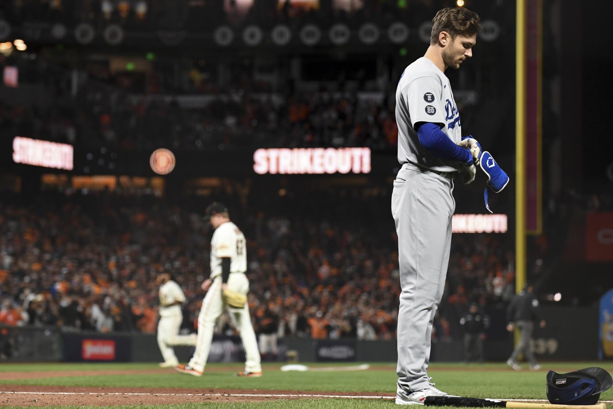 Dodgers' Trea Turner walks off the field after striking out.