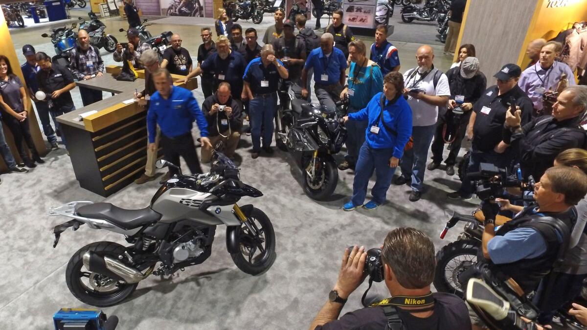 Motorcycle enthusiasts watch as BMW unveiled new product at the 2016 Progressive International Motorcycle Show in Long Beach. This year's event runs Friday through Sunday.