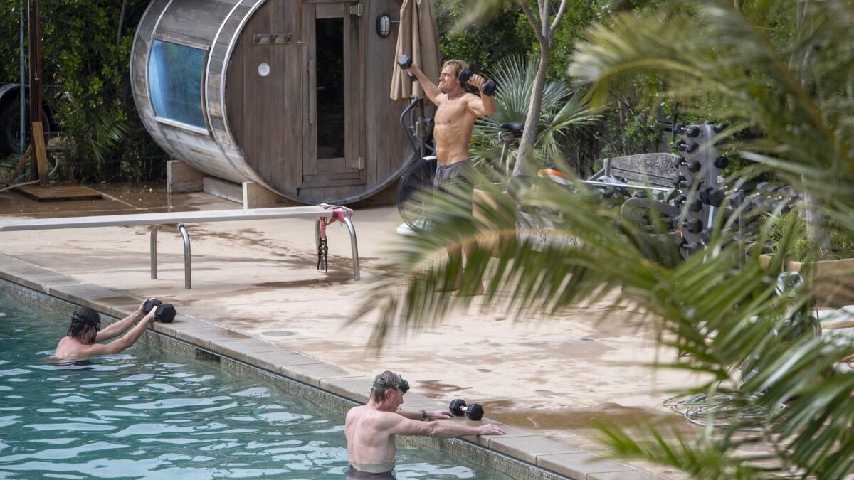 From left: Brandon Jenner, Darin Olien (standing) and Randall Wallace work out in the pool. Having access to nature and friends is important to Hamilton, especially when there is no surf. “The house is meant to be used,” adds his wife, Gabrielle Reece.