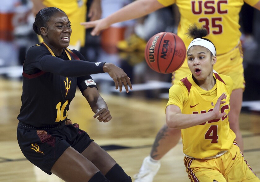 Arizona State guard Iris Mbulito (10) passes as Southern California guard Endyia Rogers (4) defends during an NCAA college basketball game in the first round of the Pac-12 women's tournament Wednesday, March 3, 2021, in Las Vegas. (AP Photo/Isaac Brekken)