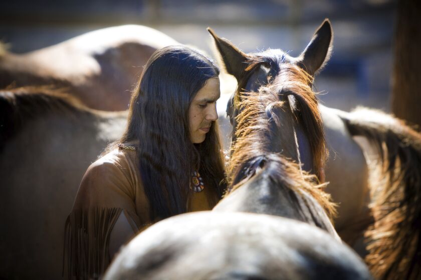 In this photo provided by Sacred Way Sanctuary, He Stalks One spends time with a horse in Alabama in 2021. These horses are the descendants of those that accompanied the Cherokee, Choctaw, Muscogee, Chickasaw and Seminole Peoples on forced removals, referred to as the "Trail of Tears.” In a study published Thursday, March 30, 2023, in the journalScience, a new analysis of horse bones gathered from museums across the Great Plains and northern Rockies has revealed that horses were present in the grasslands by the early 1600s, an earlier date than many written histories suggest. (Sacred Way Sanctuary via AP)