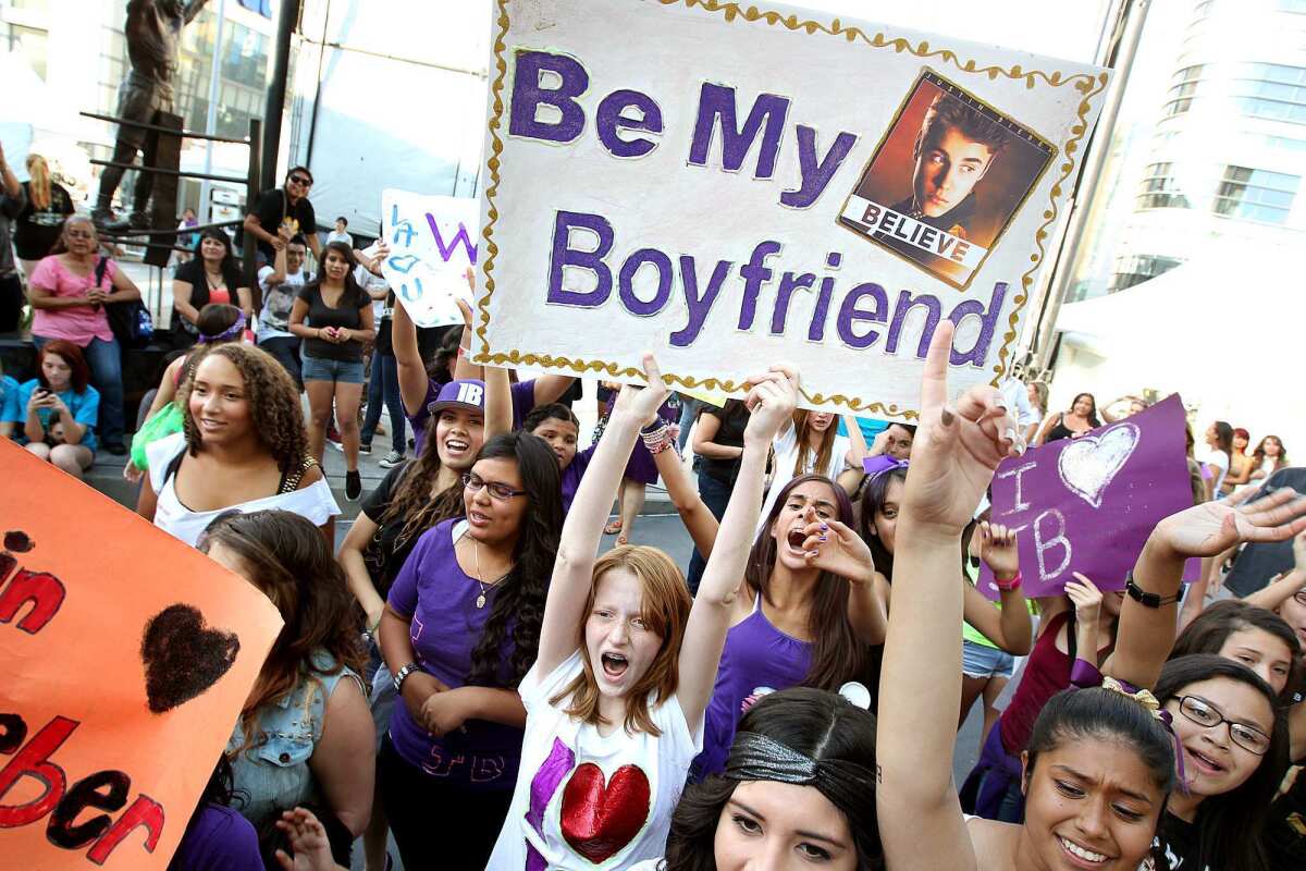 Justin Bieber fans, including Amelia Erichsen, 13, of San Diego holds a sign reading "Be My Boyfriend," before a concert at Staples Center in an undated photo.