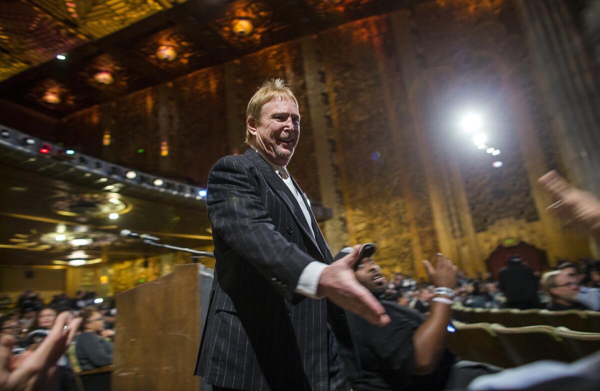 Raiders owner Mark Davis reaches to shake a fan's hand during an NFL hearing where fans pleaded to keep the franchise in Oakland.