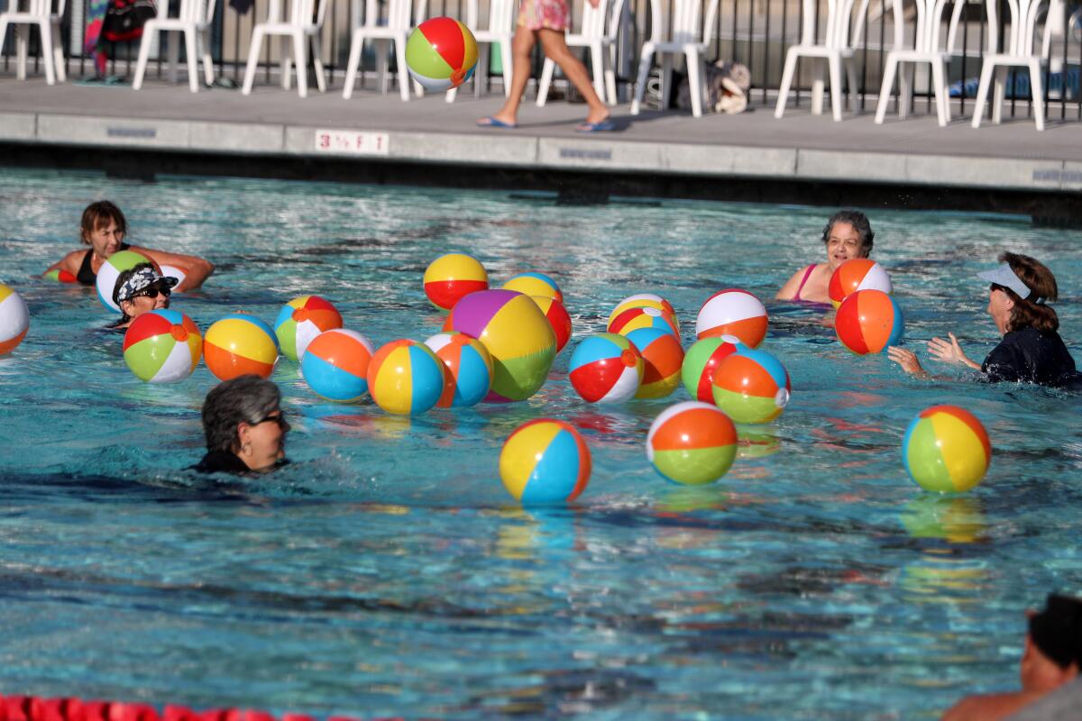Seniors jump into the pool to play with beach balls during the annual Rock-a-Hula held at the Verdugo Aquatic Center in Burbank on Thursday.