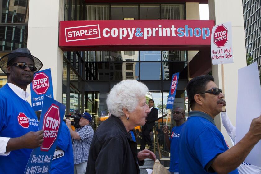 A California House delegation is urging the U.S Postal Service to reject a partnership with Staples to offer basic mail services at 82 of its stores. Above, members of the American Postal Workers Union protest Thursday at a downtown Los Angeles Staples store.