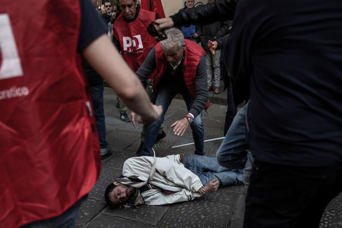 An injured man reacts on the ground next to Democratic Party activists and protesters of the No Tav movement (against the TurinLyon high-speed TAV railway line) in Turin. (MARCO BERTORELLO / AFP / Getty Images)