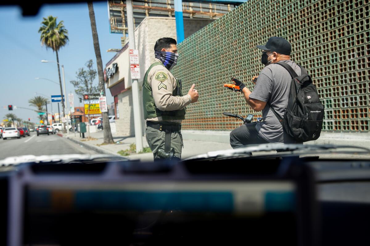 L.A. County Sheriff’s Deputy Manan Butt advises Ubaldo Delacruz that he can’t ride on the sidewalk in East Los Angeles. 