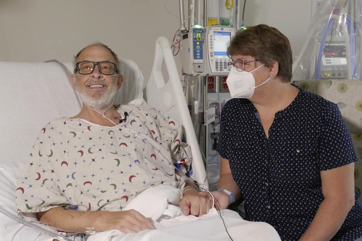 Heart transplant patient Lawrence Faucette in his hospital bed, with his wife next to him