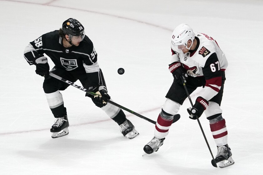 Kings defenseman Kale Clague and Arizona Coyotes left wing Lawson Crouse vie for the puck.