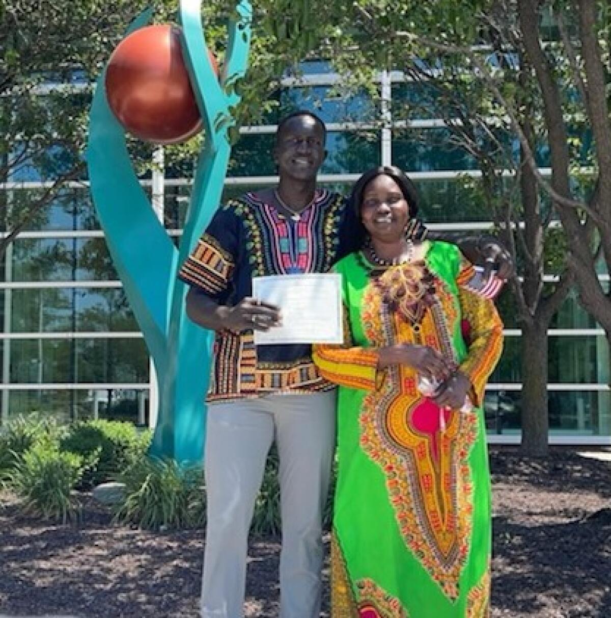 Aguek Arop and his mother pose for a photo outside the U.S. Department of Homeland Security in Omaha, Neb.