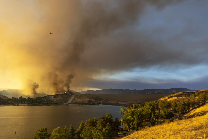 Castaic, CA - August 31: Helicopters fill with water at the Castaic Lake State Recreation Area on Wednesday, Aug. 31, 2022, in Castaic, CA. Amid searing triple-digit heat, a brush fire erupted today in dry vegetation alongside the Golden State (5) Freeway in Castaic, with the flames quickly consuming more than 165 acres.Two Los Angeles County Fire Department firefighters suffered minor heat-related injuries while battling the blaze and were taken to hospital for treatment, according to the department. (Francine Orr / Los Angeles Times)