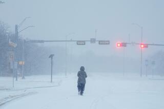 A jogger trots on a snow-covered road during a winter storm, Monday, Jan. 15, 2024, in Grand Prairie, Texas. (AP Photo/Julio Cortez)