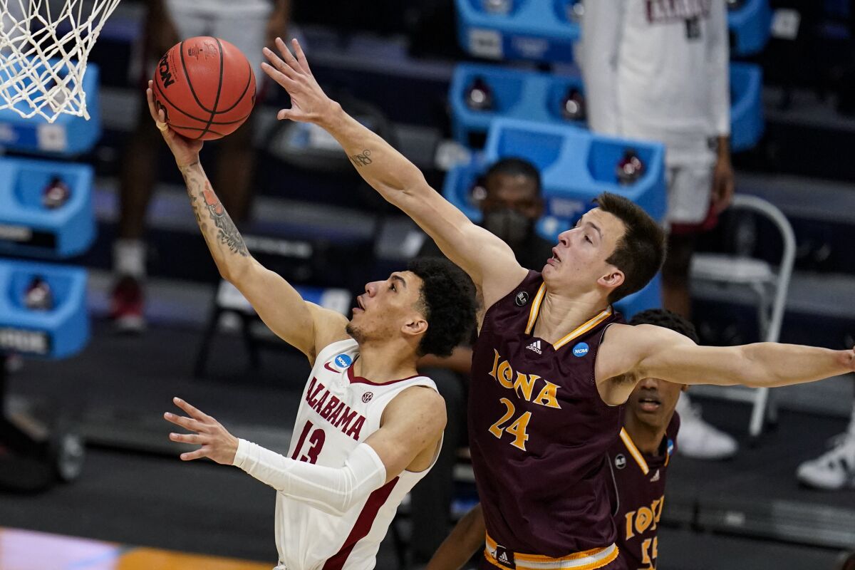 Alabama guard Jahvon Quinerly shoots in front of Iona forward Dylan van Eyck.