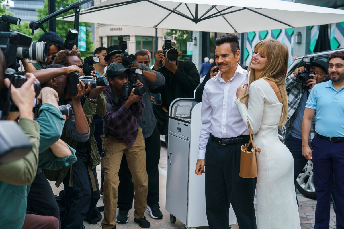 A man and a woman pose for the paparazzi.