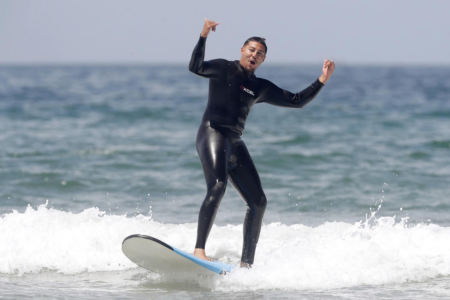 Mr. Irrelevant Caleb Wilson celebrates catching his first wave on his fourth attempt during Day 2 of the Irrelevant Week festivities in Newport Beach on Saturday. Wilson was selected with the last pick in the NFL Draft by the Arizona Cardinals.