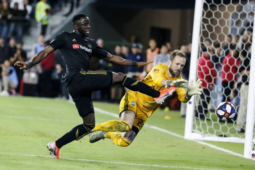 Seattle Sounders goalkeeper Stefan Frei, right, makes a save against Los Angeles FC forward Adama Diomande.