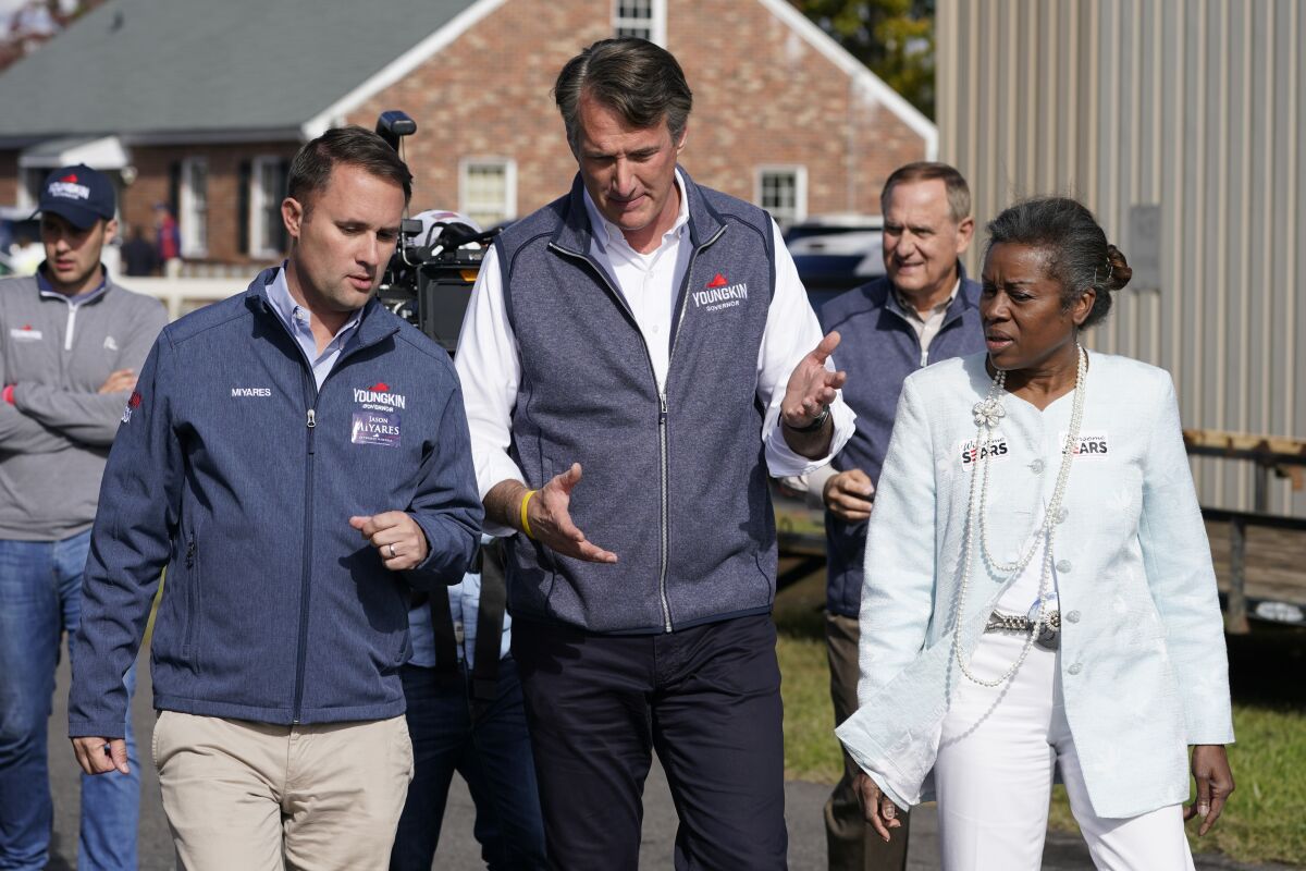 FILE - Republican gubernatorial candidate Glenn Youngkin, center, speaks with running mates, attorney general candidate, Jason Miyares, left, and lieutenant governor candidate Winsome Sears, right, as they walk from a rally in Fredericksburg, Va., Saturday, Oct. 30, 2021. Youngkin will face Democrat former Gov. Terry McAuliffe in the November election. (AP Photo/Steve Helber, File)