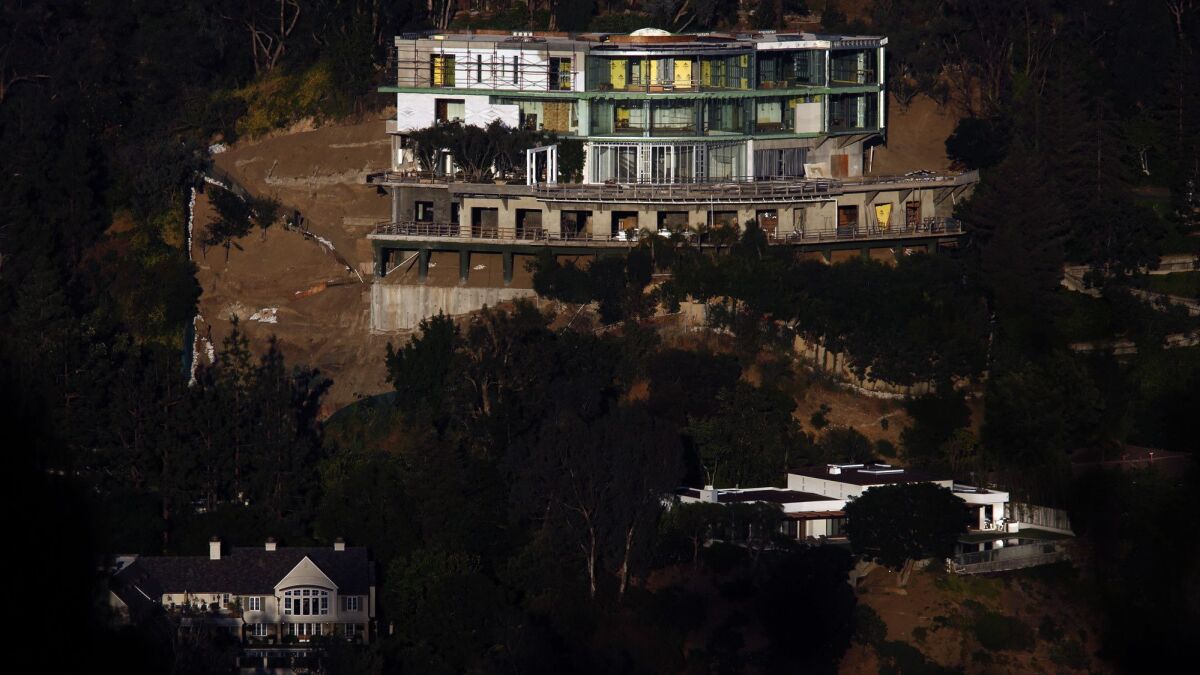 The unfinished mansion at 901 Strada Vecchia Road towers over a pair of homes in Bel-Air in 2017.