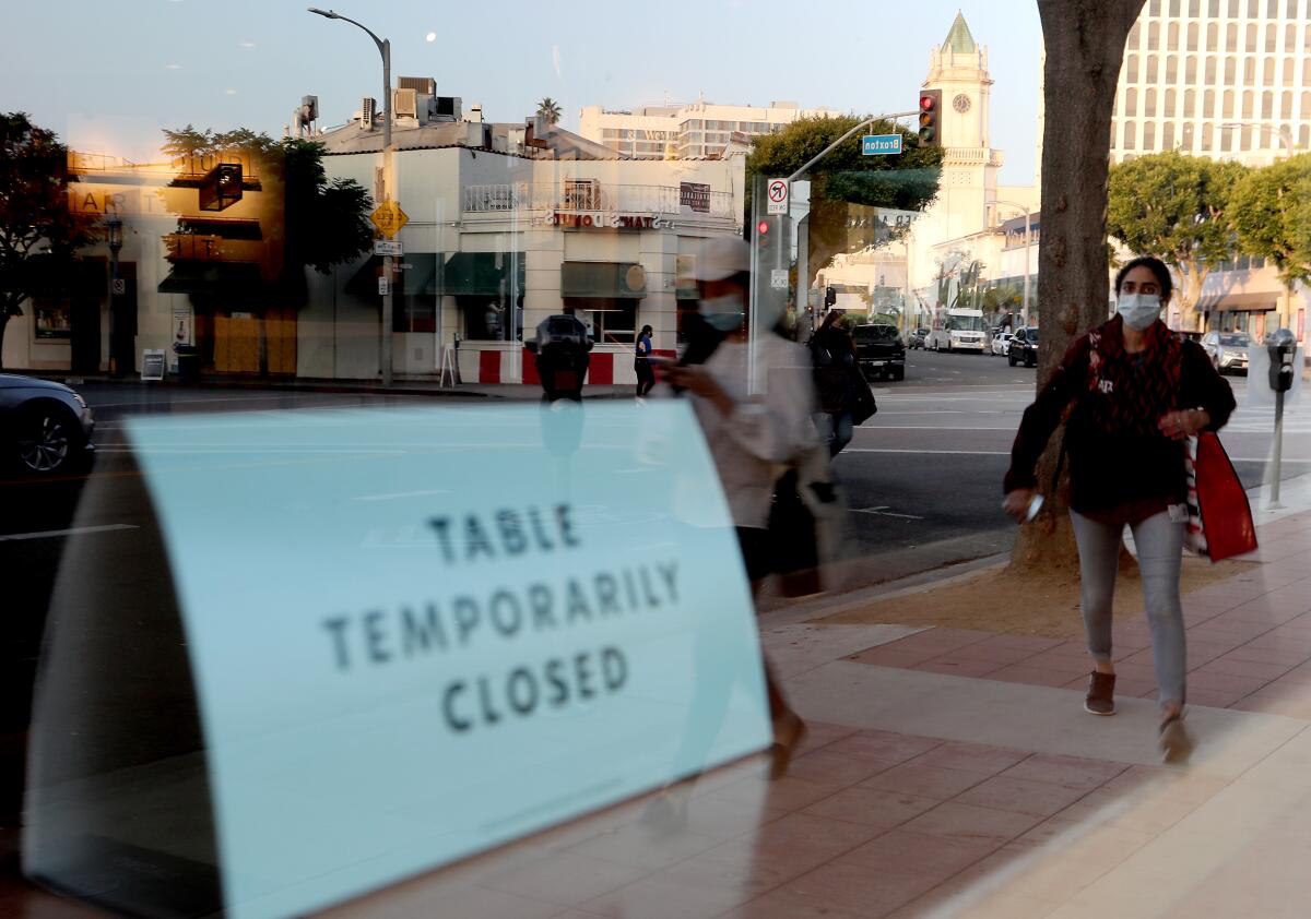 A sign reflected in a window says table temporarily closed