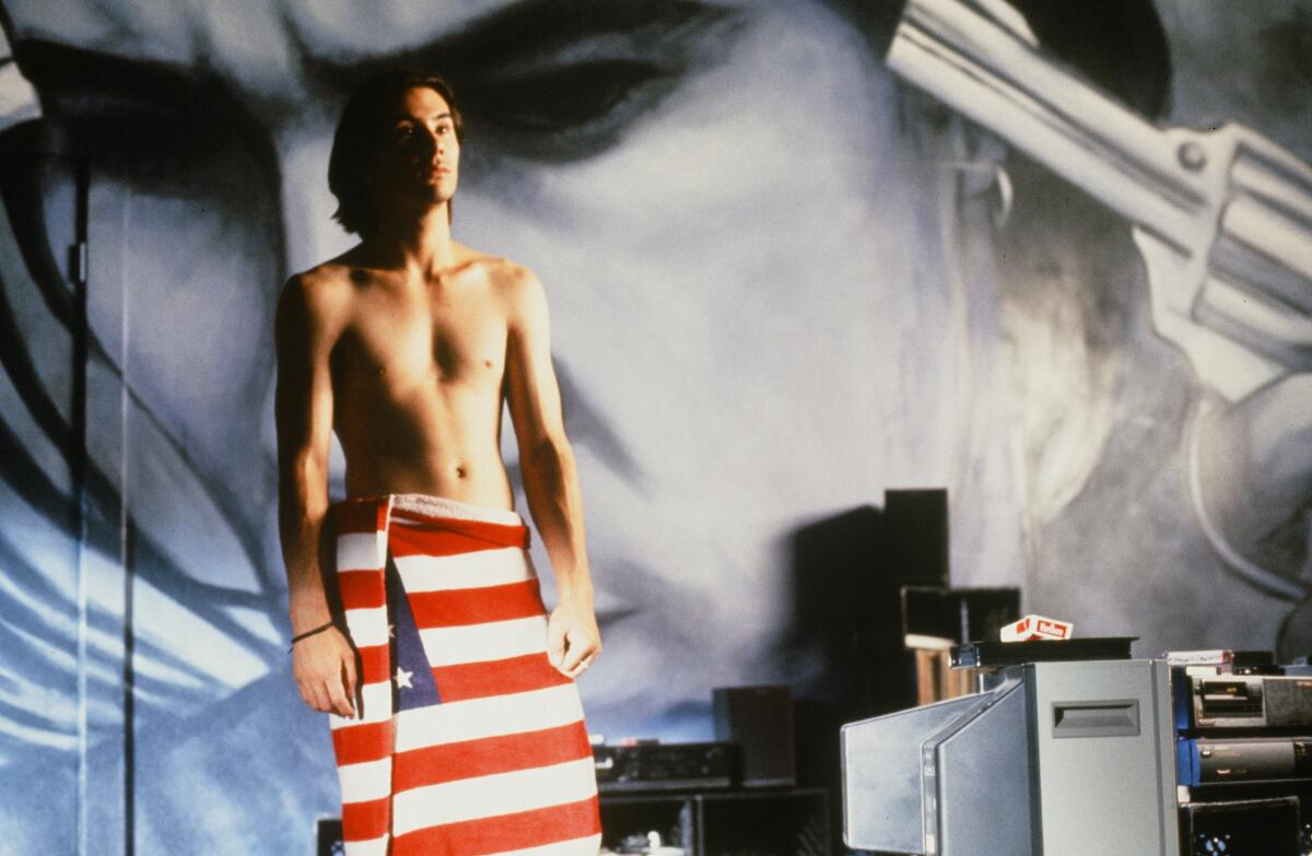 A shirtless man is wrapped in an American flag towel.