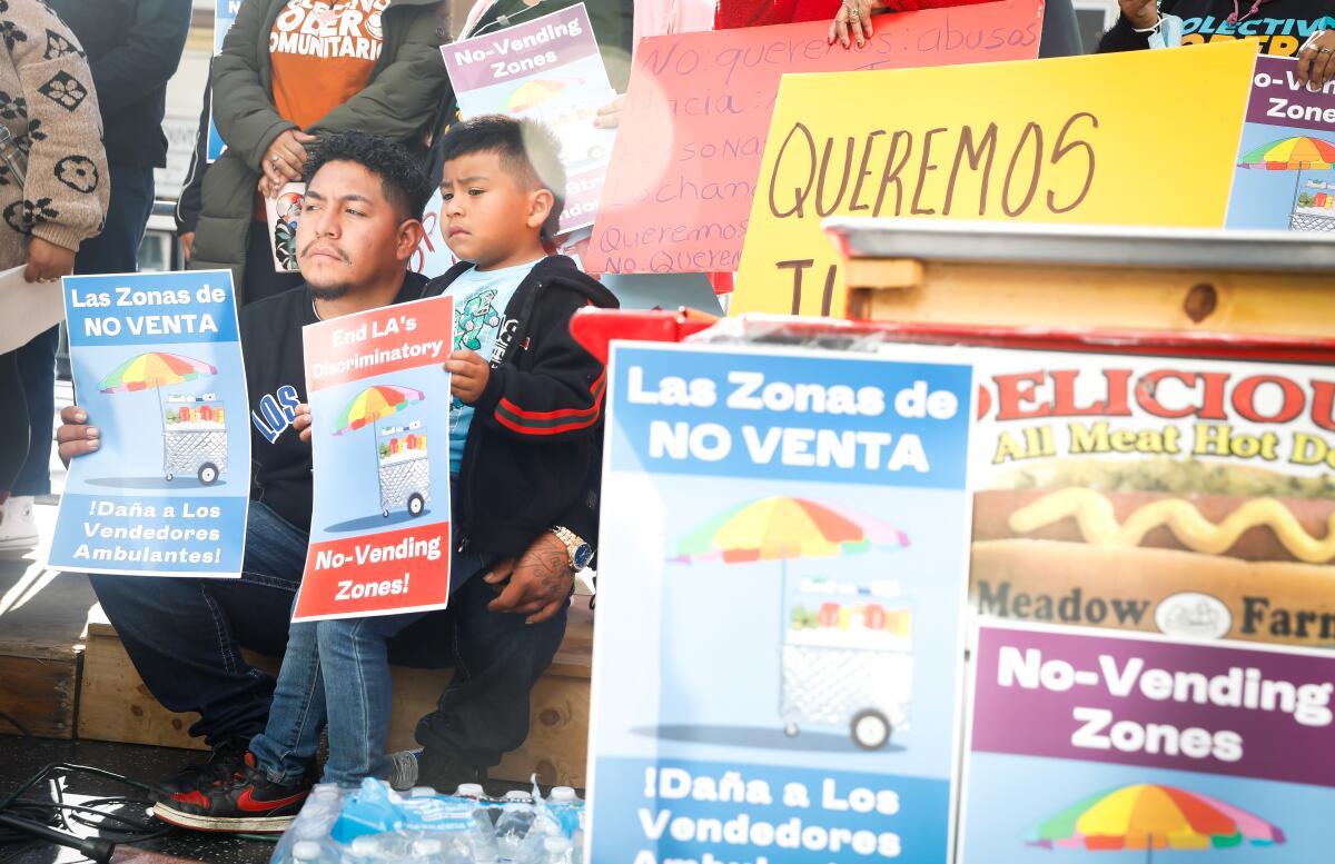 A man and boy hold signs