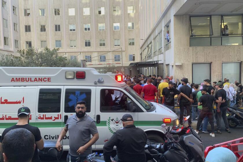 People gather outside the American University hospital after the arrival of several men who were wounded by exploded handheld pagers, in Beirut, Lebanon, Tuesday, Sept. 17, 2024. (AP Photo/Bassam Masri)