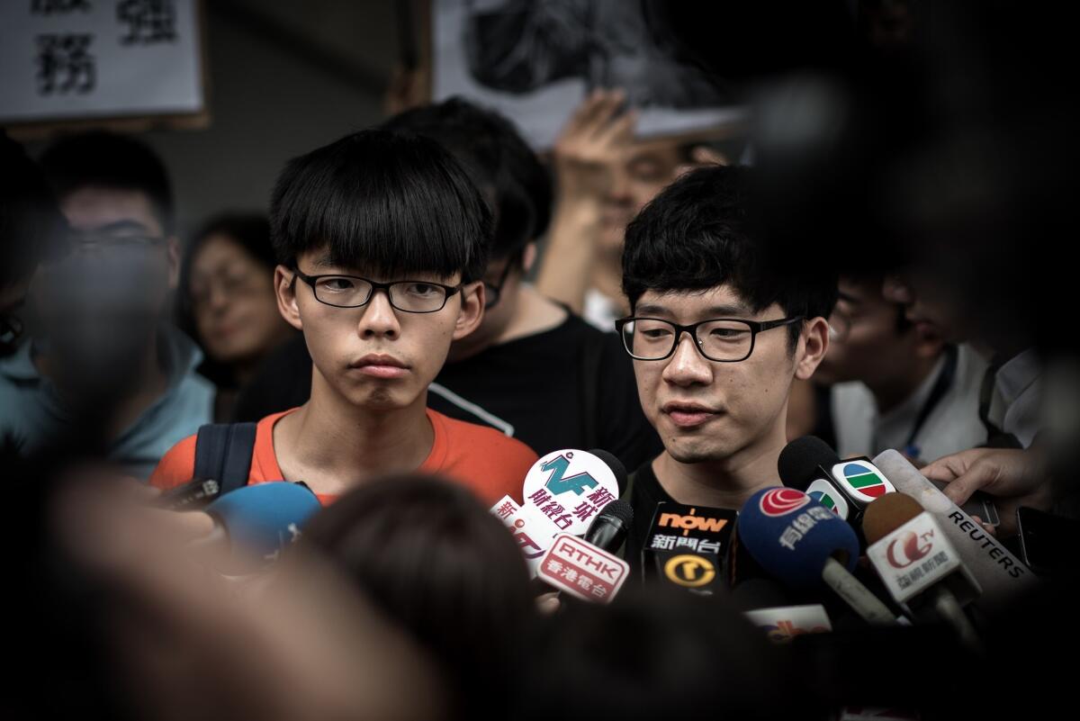 Student protesters Joshua Wong, left, and Nathan Law talk to the media outside the Wanchai police station in Hong Kong on Aug. 27, 2015. The students reported to police for investigation into their participation in a pro-democracy movement.