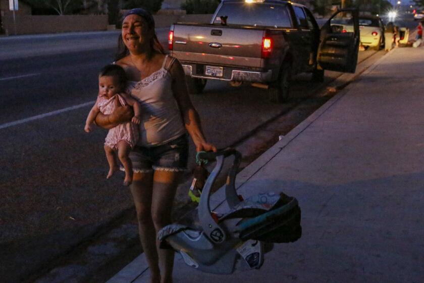 RIDGECREST, CA - JULY 05, 2019 ?Dawn Inscore is running out her apartment on Ridgecrest blvd. with her child after the Massive earthquake 7.1 hit Ridgecrest. (Irfan Khan / Los Angeles Times)