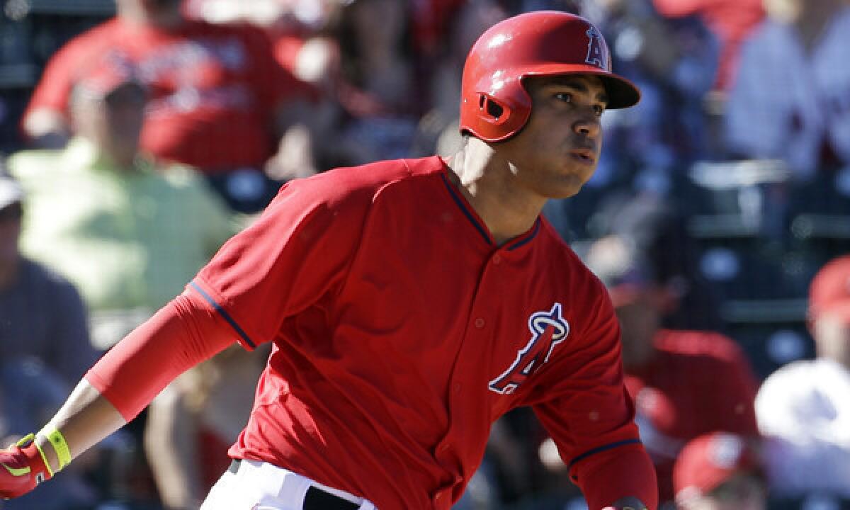 Angels first baseman hits a run-scoring single during the sixth inning of Sunday's Cactus League game against the Cincinnati Reds.