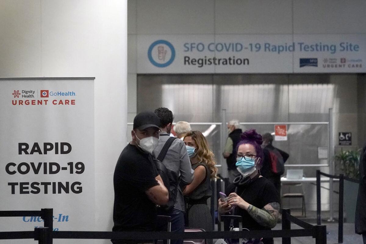 Passengers wait in line to register at the SFO COVID-19 rapid testing site at San Francisco International Airport.