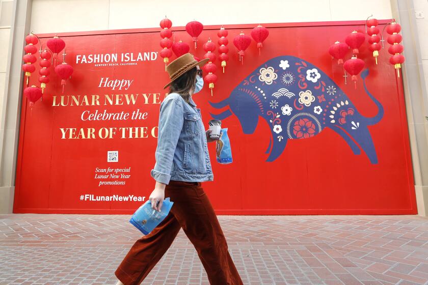 A shopper walk past the colorful Year-of-the-OX, Lunar New Year celebratory mural at Fashion on Friday. The center also has augmented reality posts in premier areas of the center, offering guests a chance to scan and celebrate Lunar New Year characters on their phones and tablets, including a cartoon ox, lanterns, or cherry blossom trees around the center grounds.