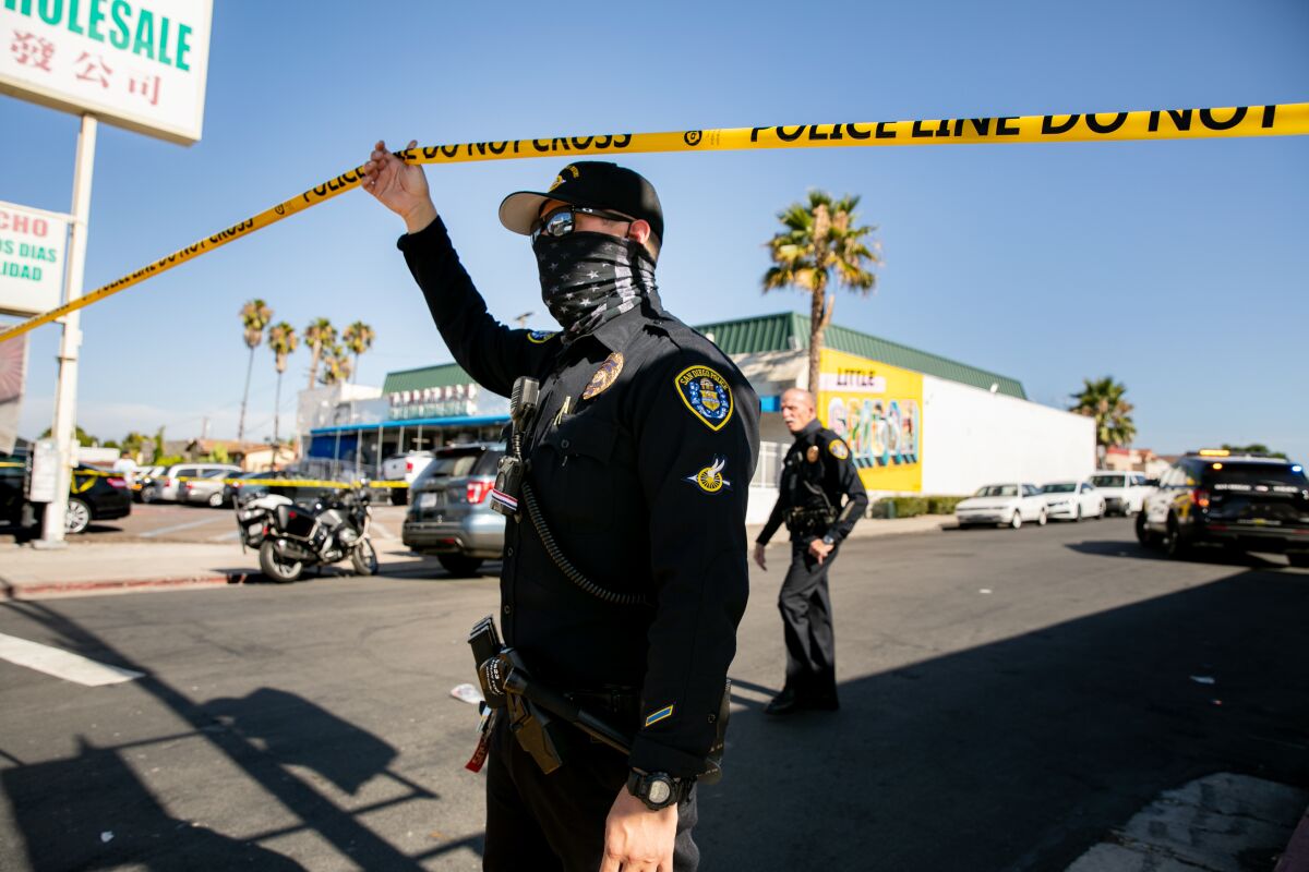 San Diego police officers stand on Menlo Avenue near El Cajon Boulevard