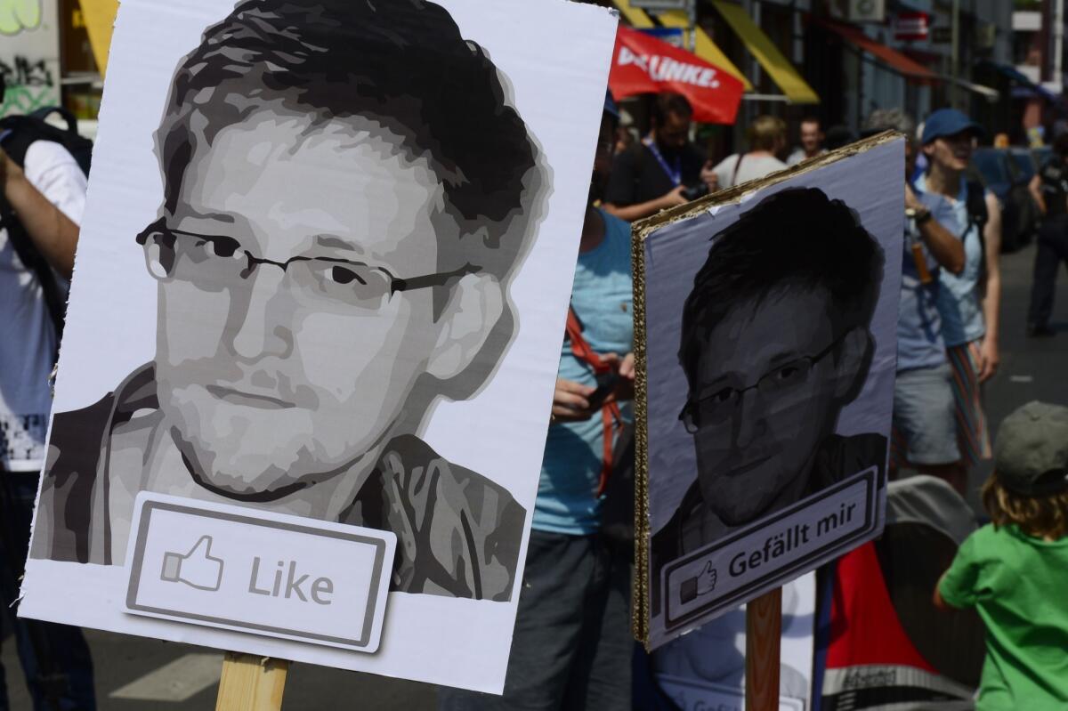 Demonstrators show support for fugitive NSA leaker Edward Snowden during a rally in Berlin on Saturday. But in Moscow, commentators are warning him that a tough life awaits if he is granted asylum.