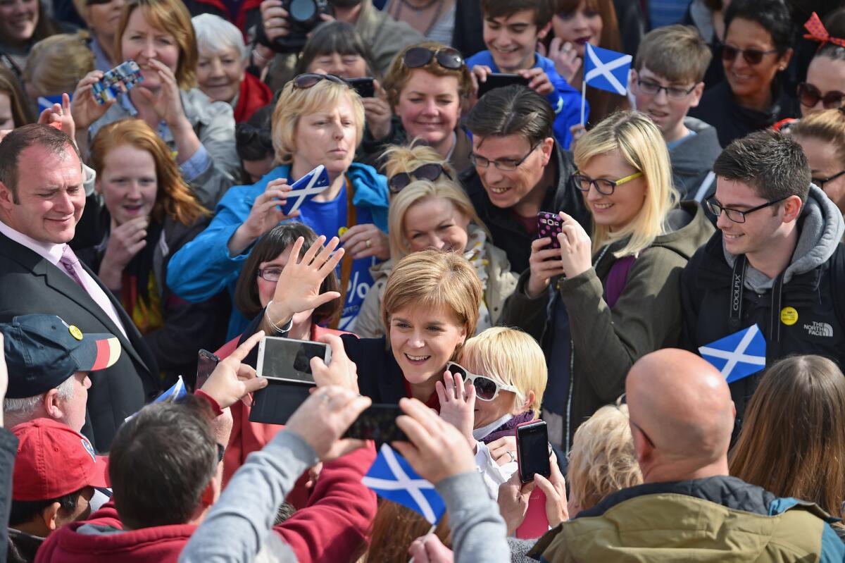 Scottish Nationalist Party leader Nicola Sturgeon, lower center, is welcomed by activists and members of the public as she campaigns for Patricia Gibson, a candidate for Parliament.