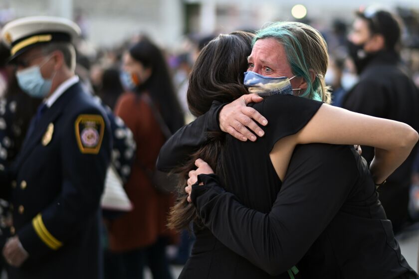 Stephanie Jayne, right, hugs a friend at a vigil at City Hall in San Jose, Calif., Thursday, May 27, 2021, in honor of the multiple people killed when a gunman opened fire at a rail yard the day before. (AP Photo/Nic Coury)