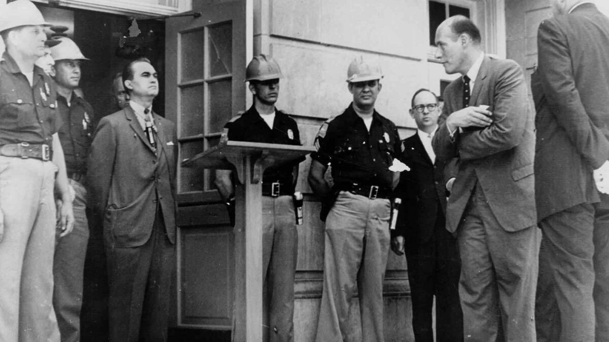 Then Alabama Gov. George Wallace, wearing suit at left, is shown on June 11, 1963, standing at the door of Foster Auditorium in Tuscaloosa, Ala., as he tries to block the admission of two black students to the then- all-white University of Alabama.