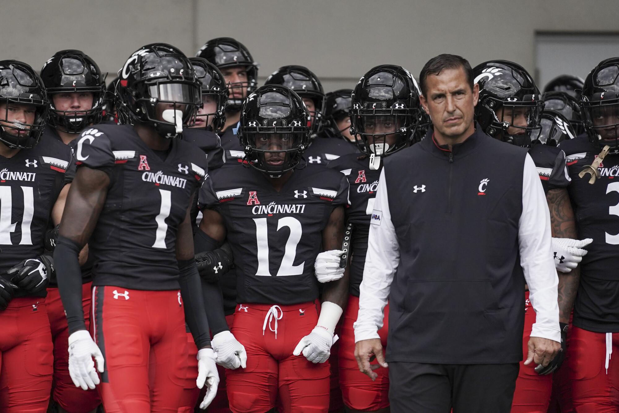 Cincinnati cornerback Ahmad Gardner (1) and  coach Luke Fickell prepare to lead their team onto the field 