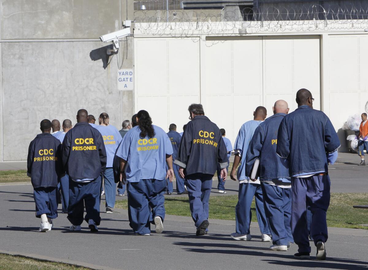 Inmates walk through the exercise yard at California State Prison Sacramento, near Folsom, Calif.