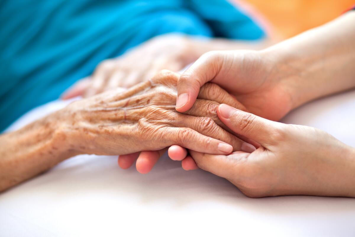 A woman holds another woman's hand in her own.