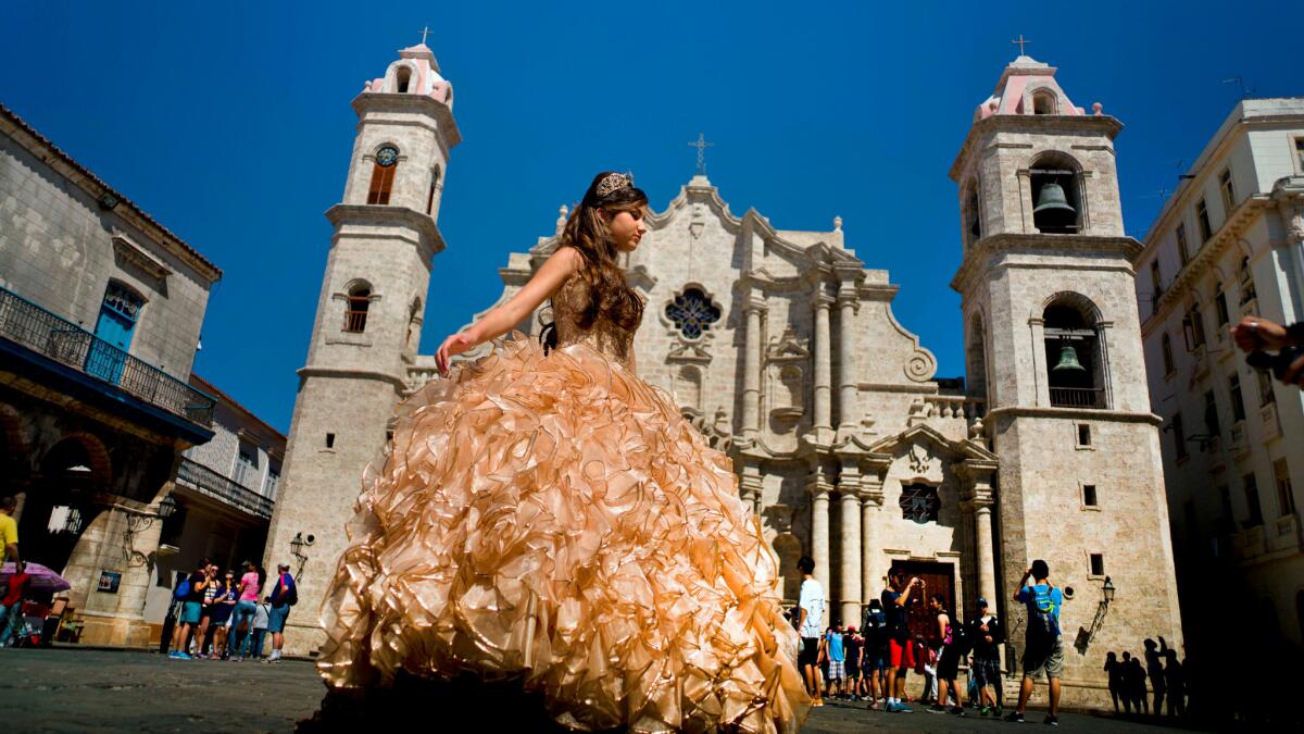 A girl celebrating her quinceañera -- her 15th birthday -- poses in front of the Havana Cathedral in March.